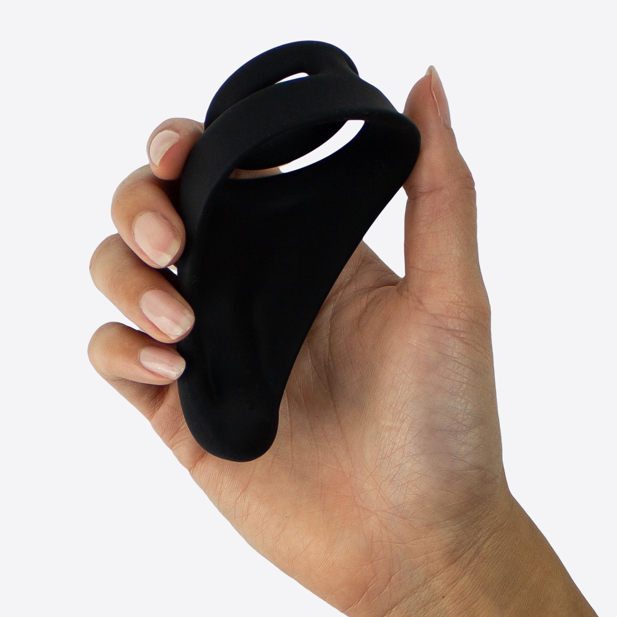 Unilove Aplha dual penis ring holdt i feminin hånd